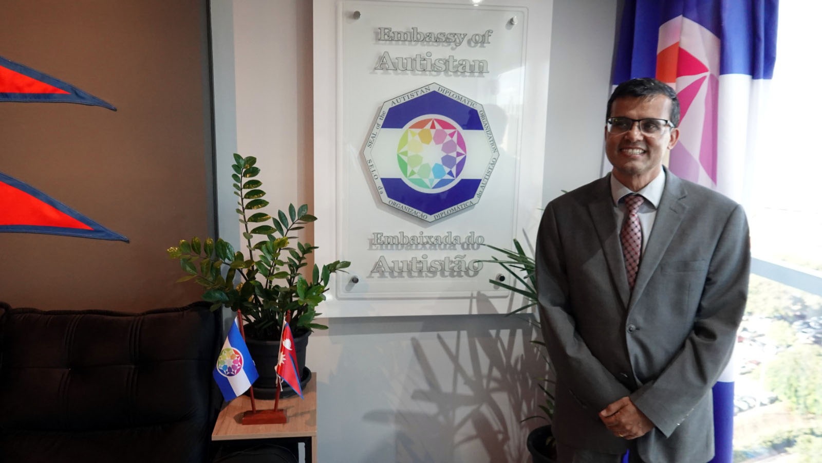 Near the plaque of the Embassy of Autistan, with the symbols of Nepal and Autistan.